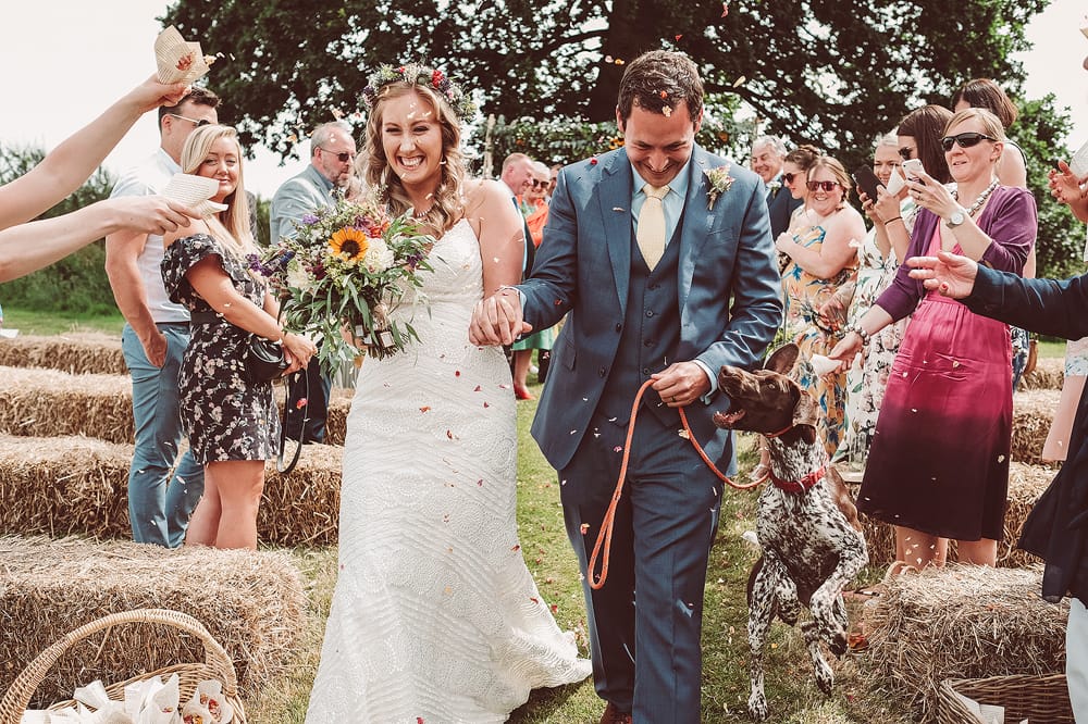 bride and groom outdoor ceremony with dog and colourful confetti